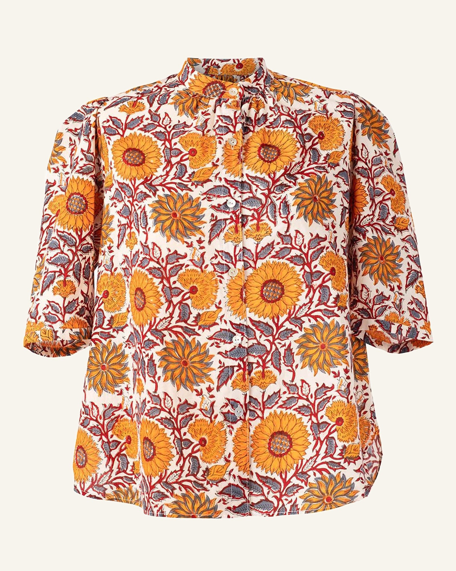 The Winnie Linnea Shirt is a women's cotton top showcasing a vibrant display of orange and yellow sunflowers accompanied by green leaves on a crisp white backdrop. This charming piece features a mandarin collar and three-quarter sleeves, seamlessly combining style with comfort.