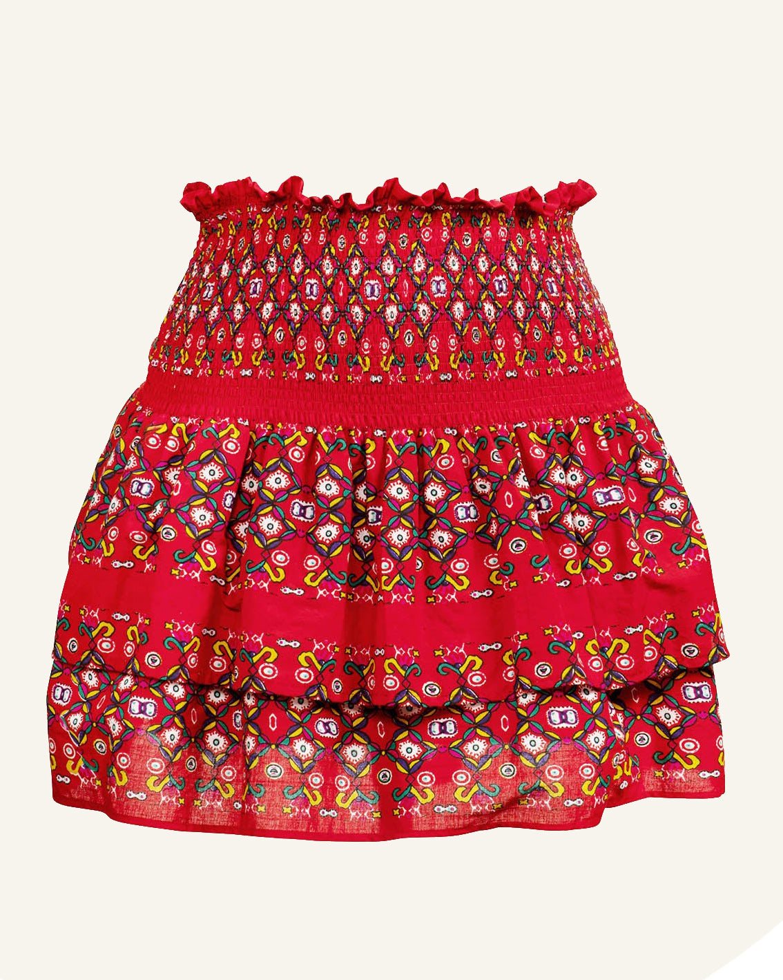 The Marina Holiday Skirt is a vibrant red piece adorned with intricate multicolored geometric and floral patterns. It features a wide, gathered waistband and a tiered design. Pair it with a puff sleeve top for an effortlessly playful and colorful aesthetic.