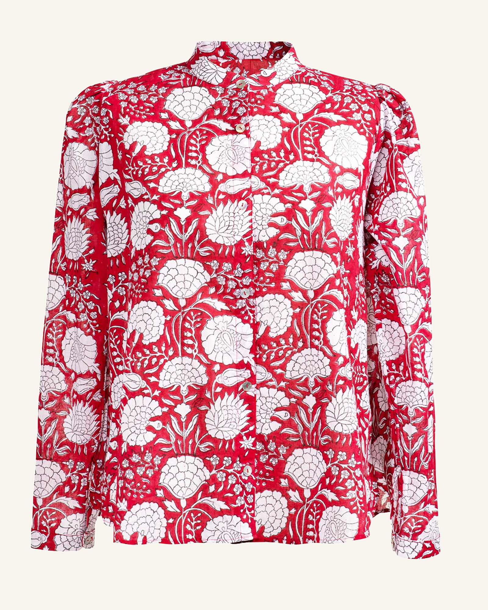 The Annabel Crimson Shirt is a women's blouse characterized by its red and white floral design. Made from soft cotton, this shirt includes a button-up front and long sleeves, showcasing an intricate pattern of flowers and leaves set against a light background.