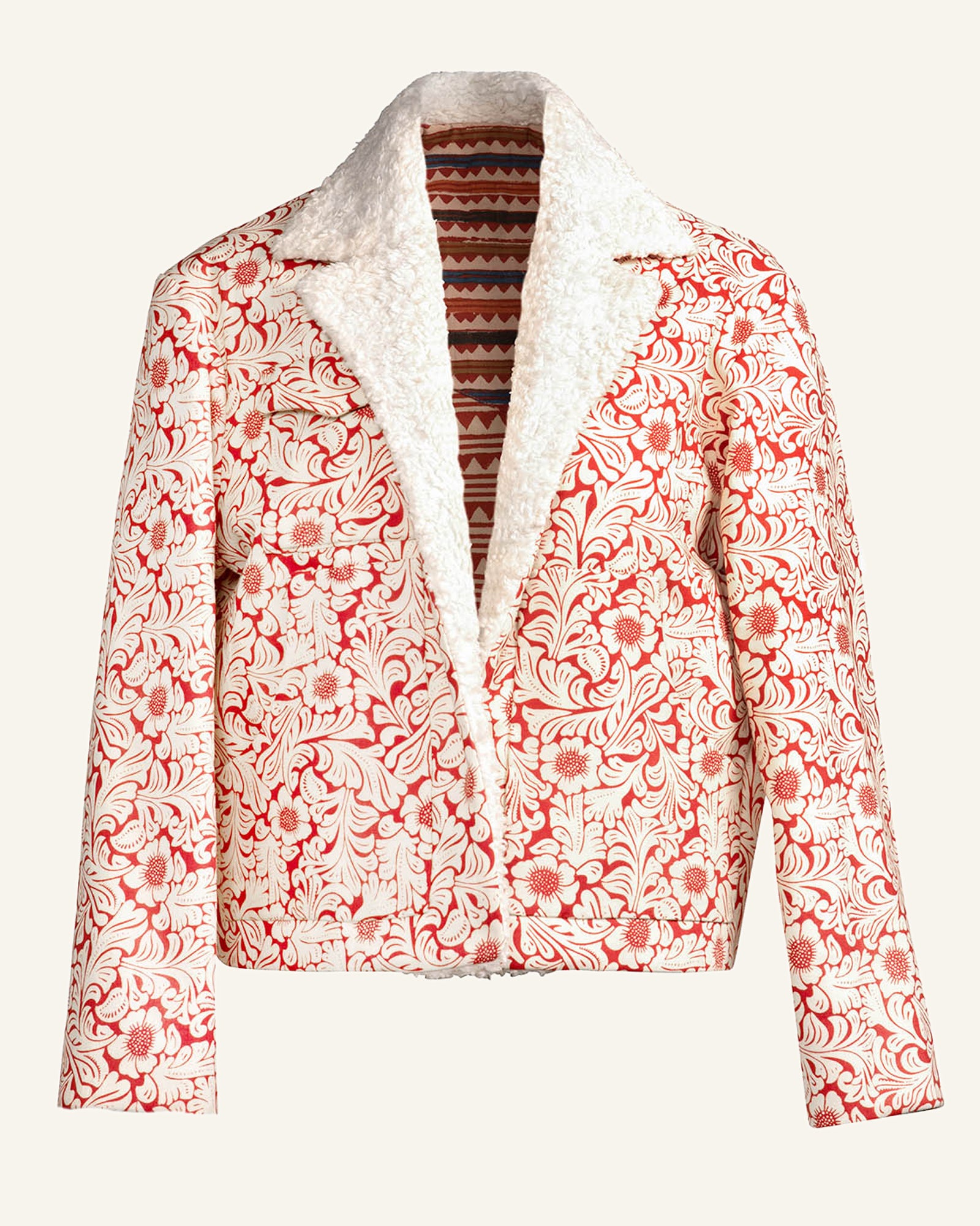 Introducing the Red Rover Sherpa Jacket, featuring a chic red floral pattern set against a white backdrop. This stylish piece includes a cozy white sherpa lining that is visible on the lapels and inner sides, accented by a geometric patterned interior. The paisley-inspired design brings an element of elegance to the minimalist light background.