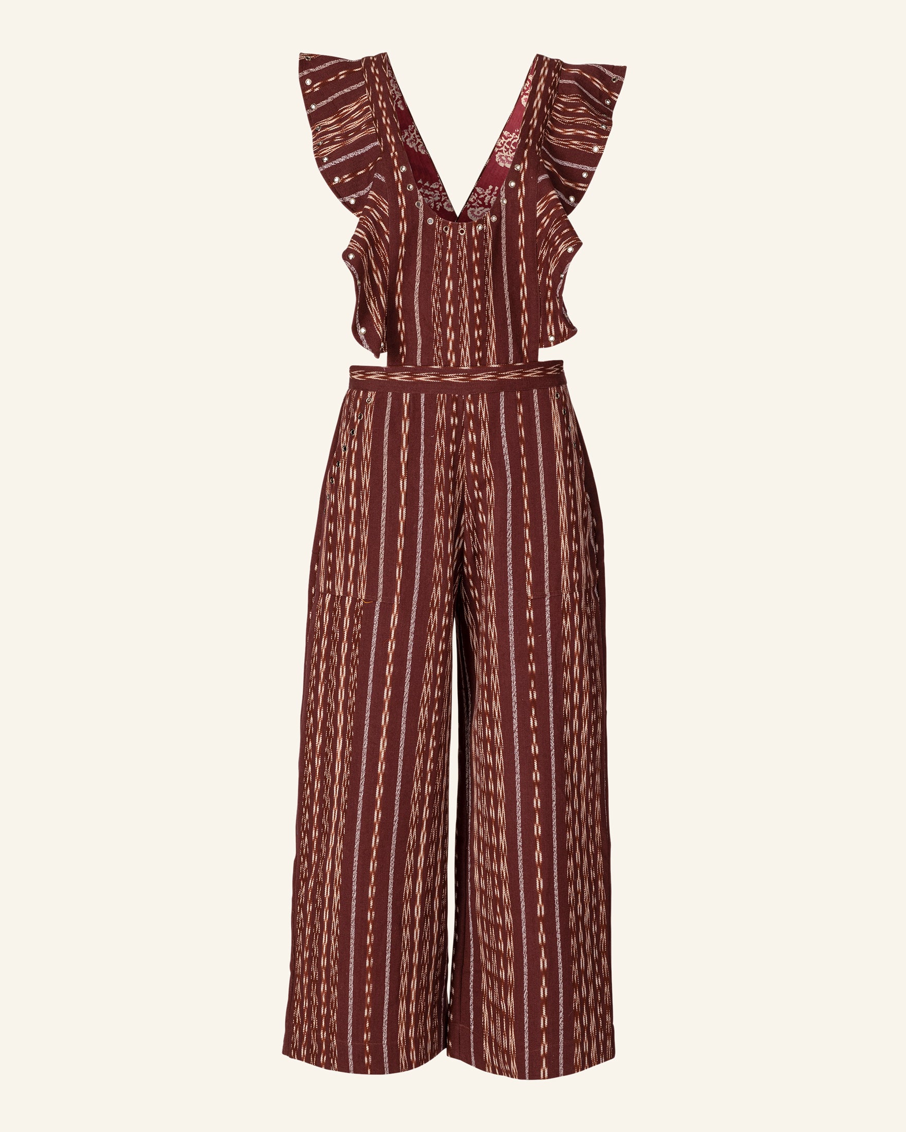 The Indie Tobacco Ikat Overall is a brown and cream patterned jumpsuit that boasts a deep V-neckline, ruffled shoulder straps, a fitted waist, and wide-leg pants. This piece is crafted using traditional methods, featuring fabric with vertical stripes and intricate details inspired by Guatemalan Ikat.