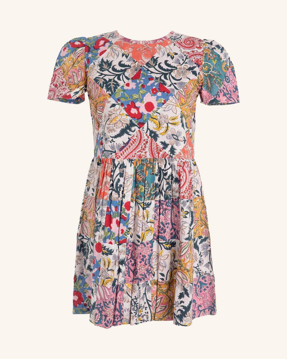 Introducing the Mila Patchwork Mini Dress, a vibrant and artistic piece with short sleeves and a round neckline. This dress showcases a colorful array of floral patterns with leaves, crafted from hand-quilted upcycled scraps for an eye-catching patchwork design.