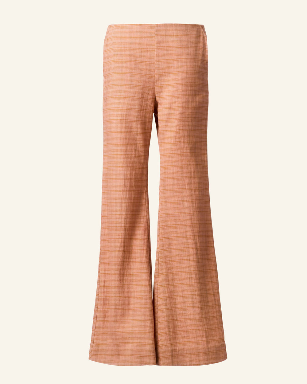 The Charlie Juted Rose Pant is a pair of high-waisted, wide-leg pants in a textured, earthy orange fabric with a tea rose hue. It features a subtle vertical stripe pattern and a hand-stitched hem, captured beautifully against a plain, light beige background.