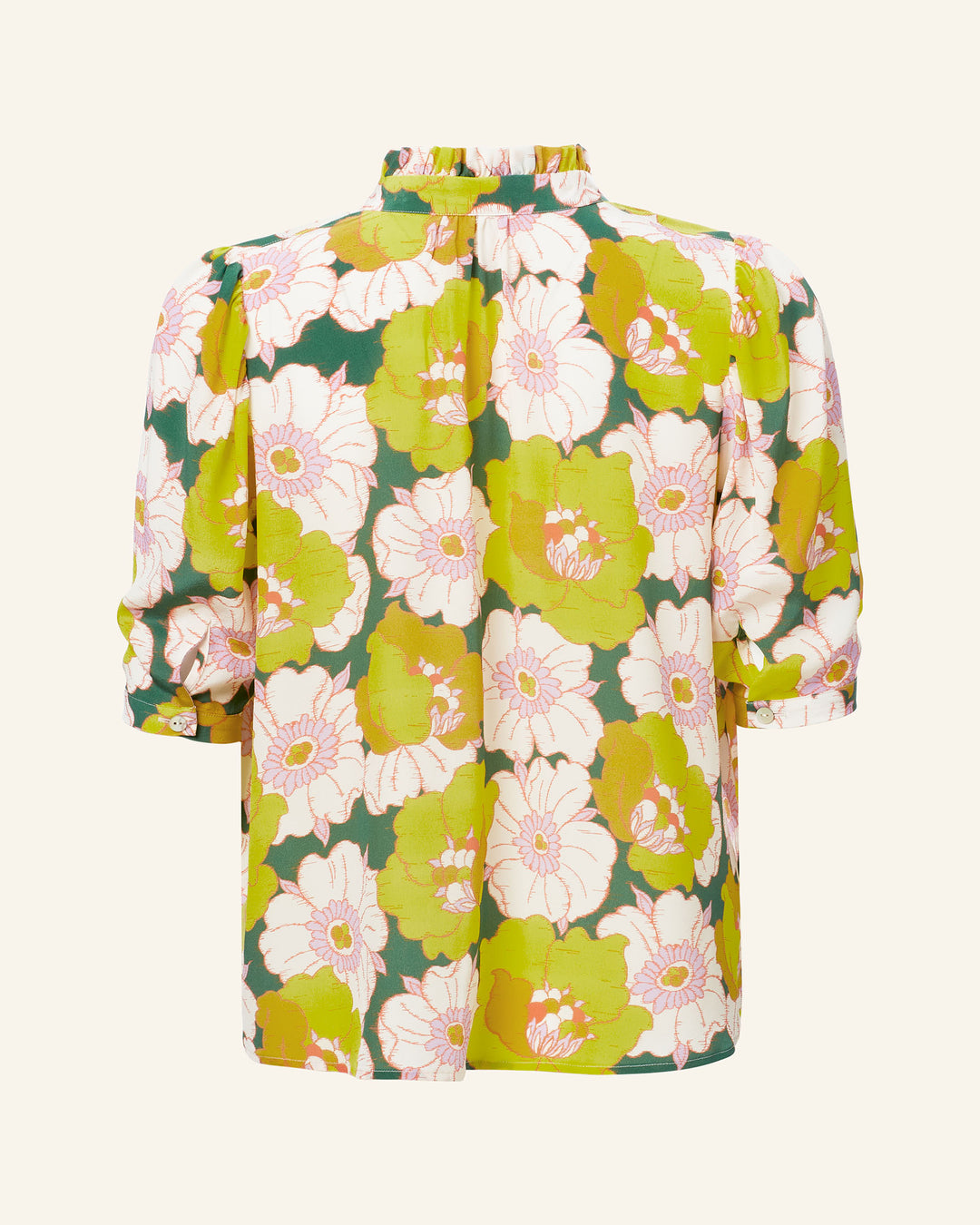 The Winnie Citrus Blossom Silk Shirt is an elegant Liberty-print floral blouse, featuring green and white flowers. Made from luxurious Italian silk, it highlights a high neckline with a ruffled collar and stylish three-quarter sleeves, elegantly showcased from the back.