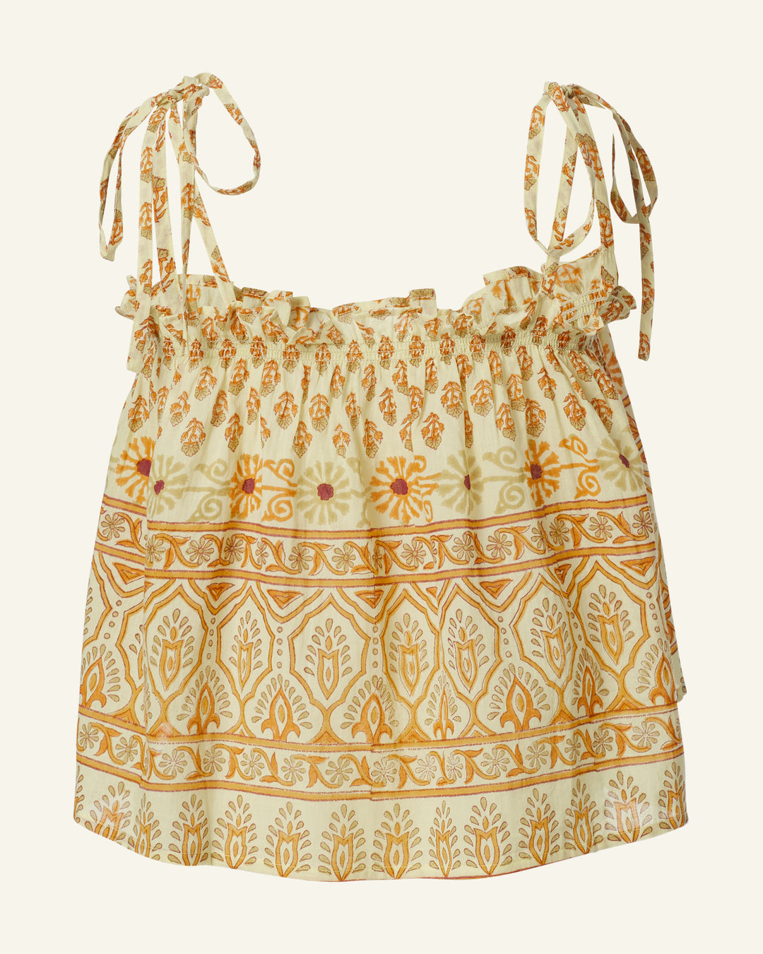 The Lila Saffron Bhutti Top is a sleeveless blouse made from soft cotton voile, featuring adjustable shoulder ties. It boasts intricate block-printed yellow and orange floral designs along with geometric patterns on a light background, giving it a bohemian flair.