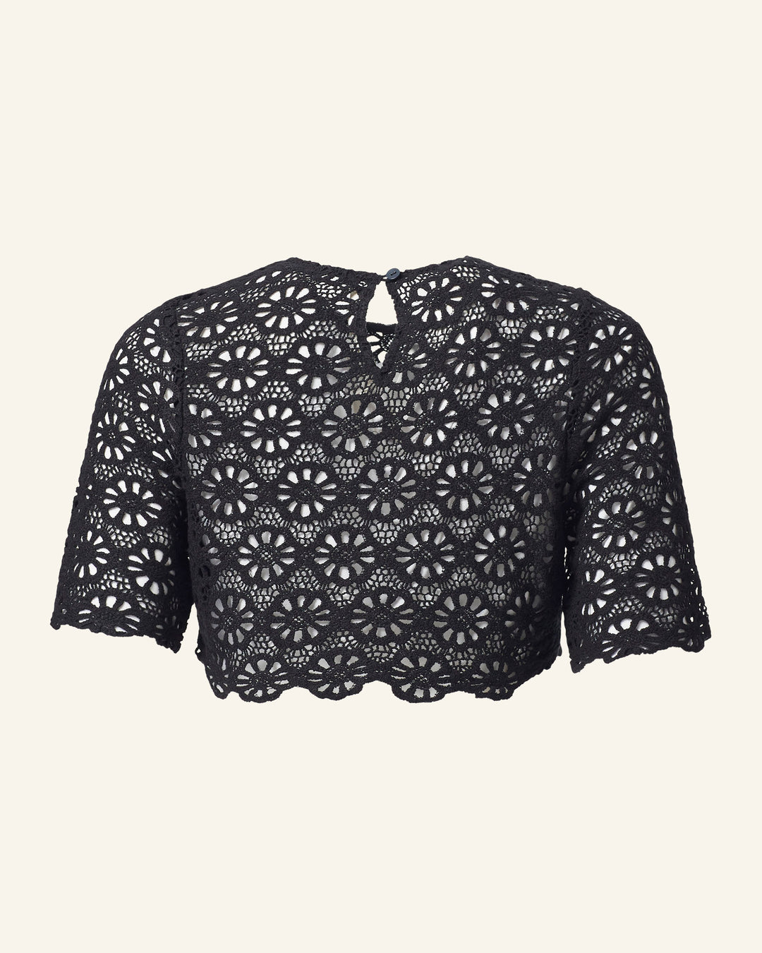 Introducing the Nala Onyx Lace Cropped Top, a captivating black cotton piece adorned with a charming daisy motif. This top features a scalloped hem and short sleeves, with a stylish keyhole button closure near the neckline at the back.