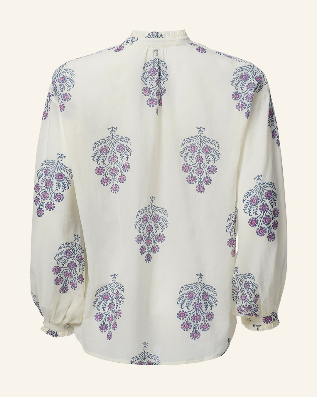 The Poet Freesia Phlox Blouse is a white long-sleeved blouse adorned with a repeated floral pattern in purple and blue, reminiscent of a vintage-inspired folk shirt. Its elegant design includes a high collar and buttoned cuffs, crafted in soft, lightweight fabric.