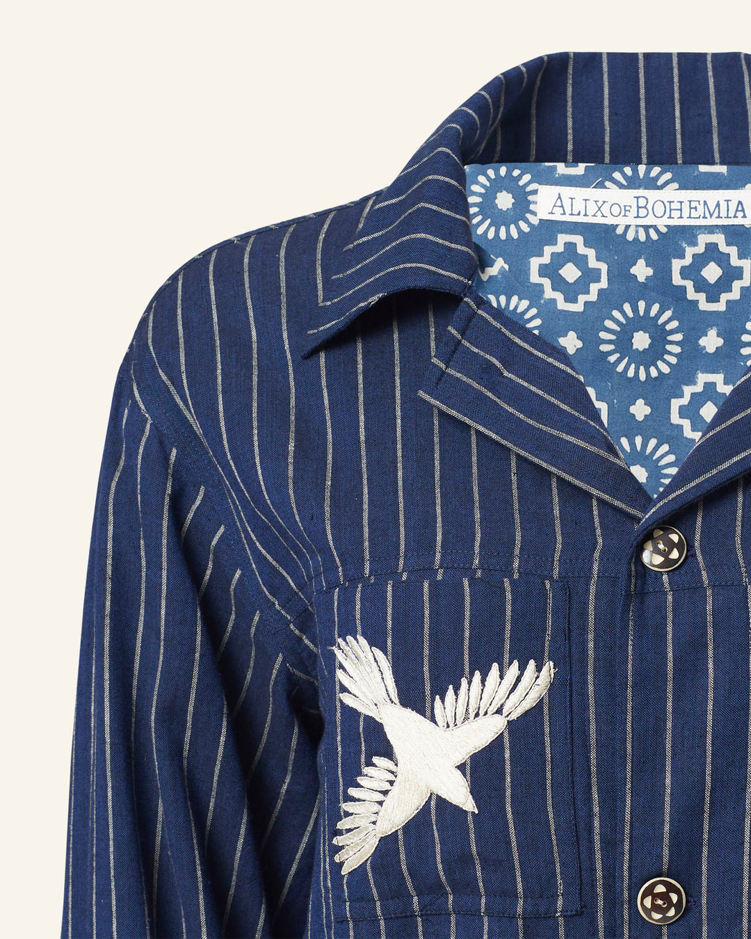 Product: Seba Luna Night Jacket crafted from Khadi cotton, with an embroidered white bird on the pocket and a blue geometric pattern on the inner collar. Label reads "Alix of Bohemia.