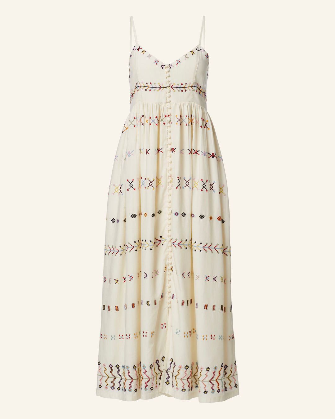 Introducing the Skylar Aurora Arrow Dress: an ivory sleeveless summer dress that boasts a vibrant geometric hand-embroidered pattern. This dress features thin straps, a fitted bodice, and a flowing skirt adorned with shapes and designs in striking shades of red, blue, yellow, and brown.