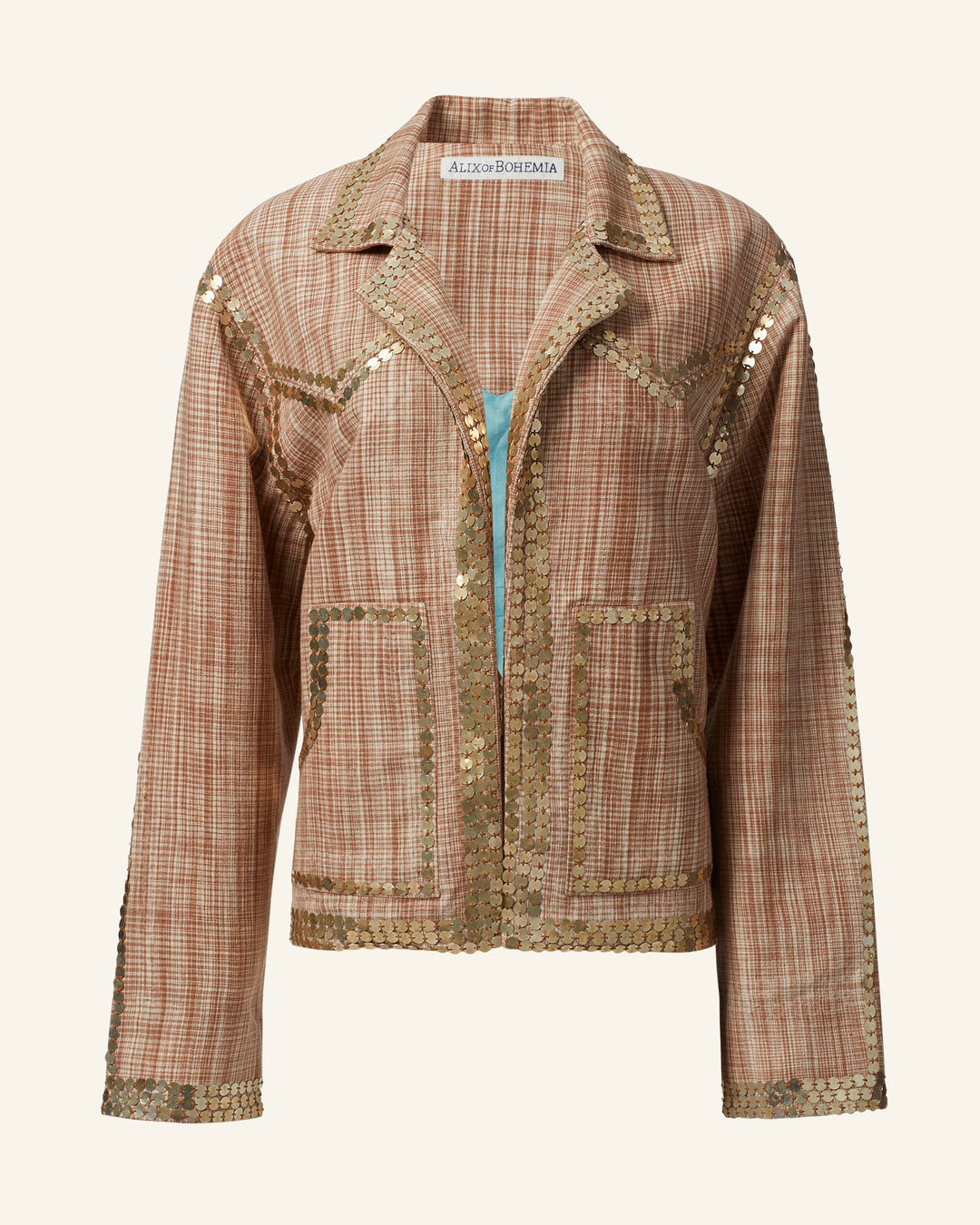 The Western Sand Coin Jacket, a brown checked design adorned with gold sequins on the collar, cuffs, seams, and pockets, is showcased against a beige background. Expertly crafted by hand, the jacket features a subtle shimmering effect.