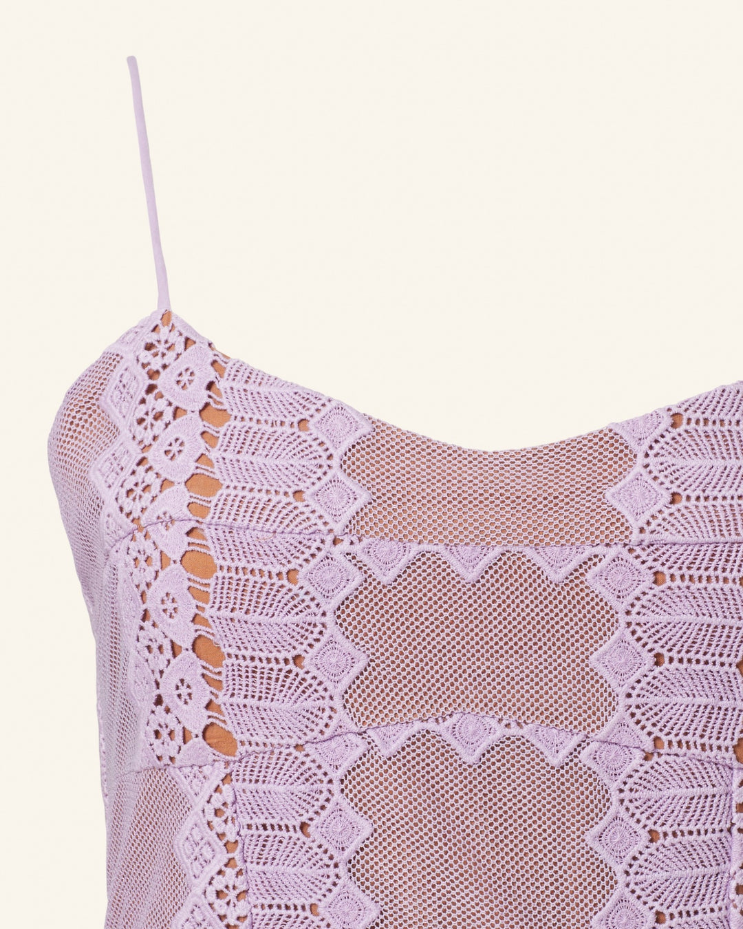 Close-up of the Autumn Lavender Picnic Dress, a lavender lace midi dress adorned with intricate patterns and spaghetti straps. Perfect for wedding guests, it showcases both floral and geometric elements that create a delicate and elegant appearance. The neutral background accentuates the dress's exquisite details.