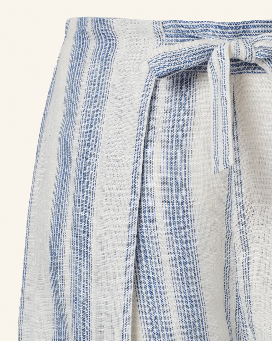 Close-up of the Bonnie Pacific Wrap Pant, crafted from vertically striped silk chiffon fabric in blue and white. The pant features a tied bow detail on the right side, highlighting its vintage-inspired design. The texture appears light and airy.