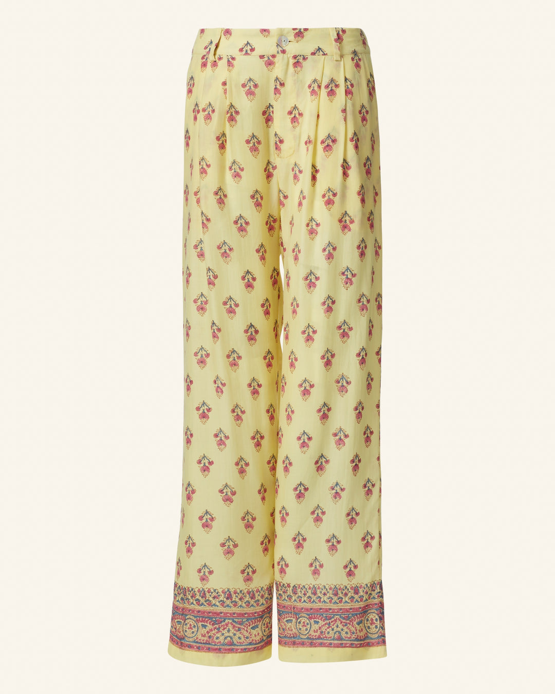 The Colette Primrose Bhutti Pant is a high-waisted design featuring yellow wide-leg linen with a floral pattern and a decorative border at the hem for added style.