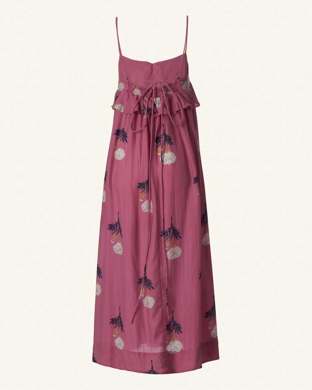 The Martina Hibiscus Rose Dress is a sleeveless pink floral print maxi dress with spaghetti straps made from Tencel fabric, featuring a ruffled top and tie detail on the front—perfect for a summer outing.