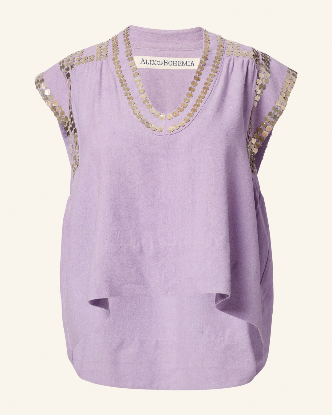 The Nehru Lavender Coin Top is a sleeveless design embellished with gold sequin detailing around the neckline and shoulders. Made from luxurious Banaras silk, it offers a loose fit with a gathered and draped front. The tag reads "ALIX of BOHEMIA.