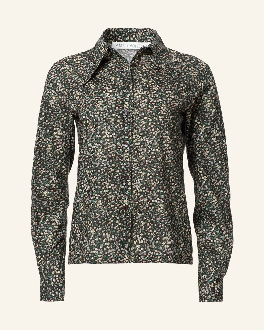 The Dolly Moonflower Shirt is a long-sleeve, collared shirt featuring a dark green and white floral Liberty-print pattern on a plain background, exuding a vintage-inspired charm.