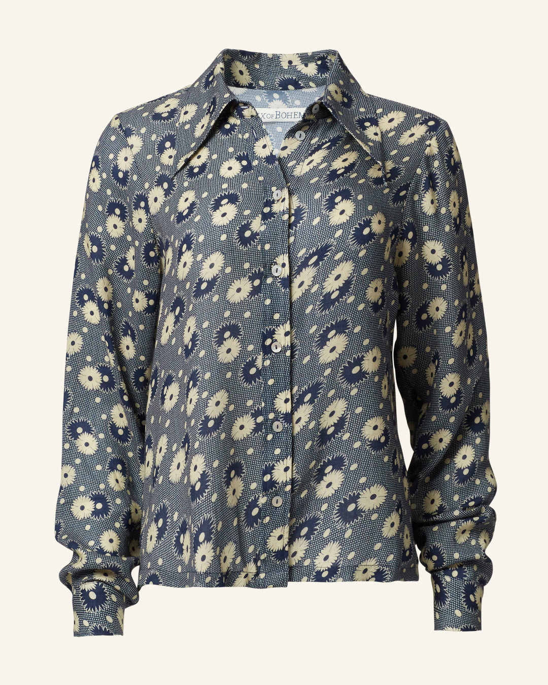 The Dolly Navy Daisy Shirt features a '70s-style design with navy floral patterns, a button-up front, and a collar, making it perfect for adding vintage-inspired charm to any outfit.