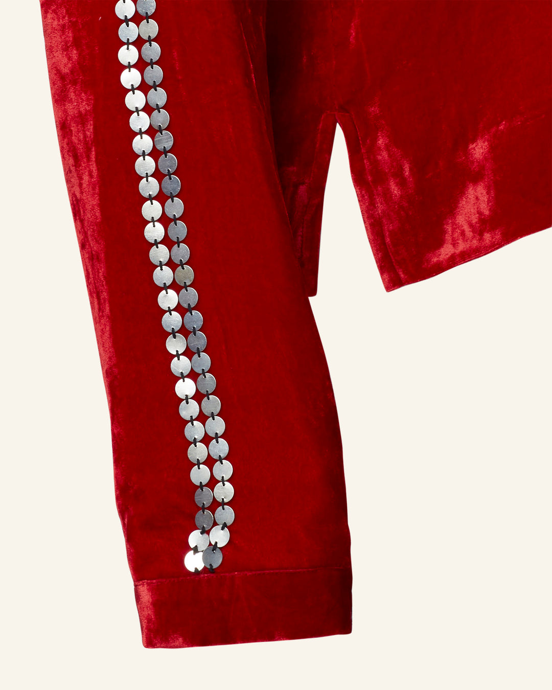 The Dylan Ruby Velvet Tunic is a luxurious Western-inspired piece crafted from rich red velvet and highlighted by sleeves adorned with a row of circular silver sequins.