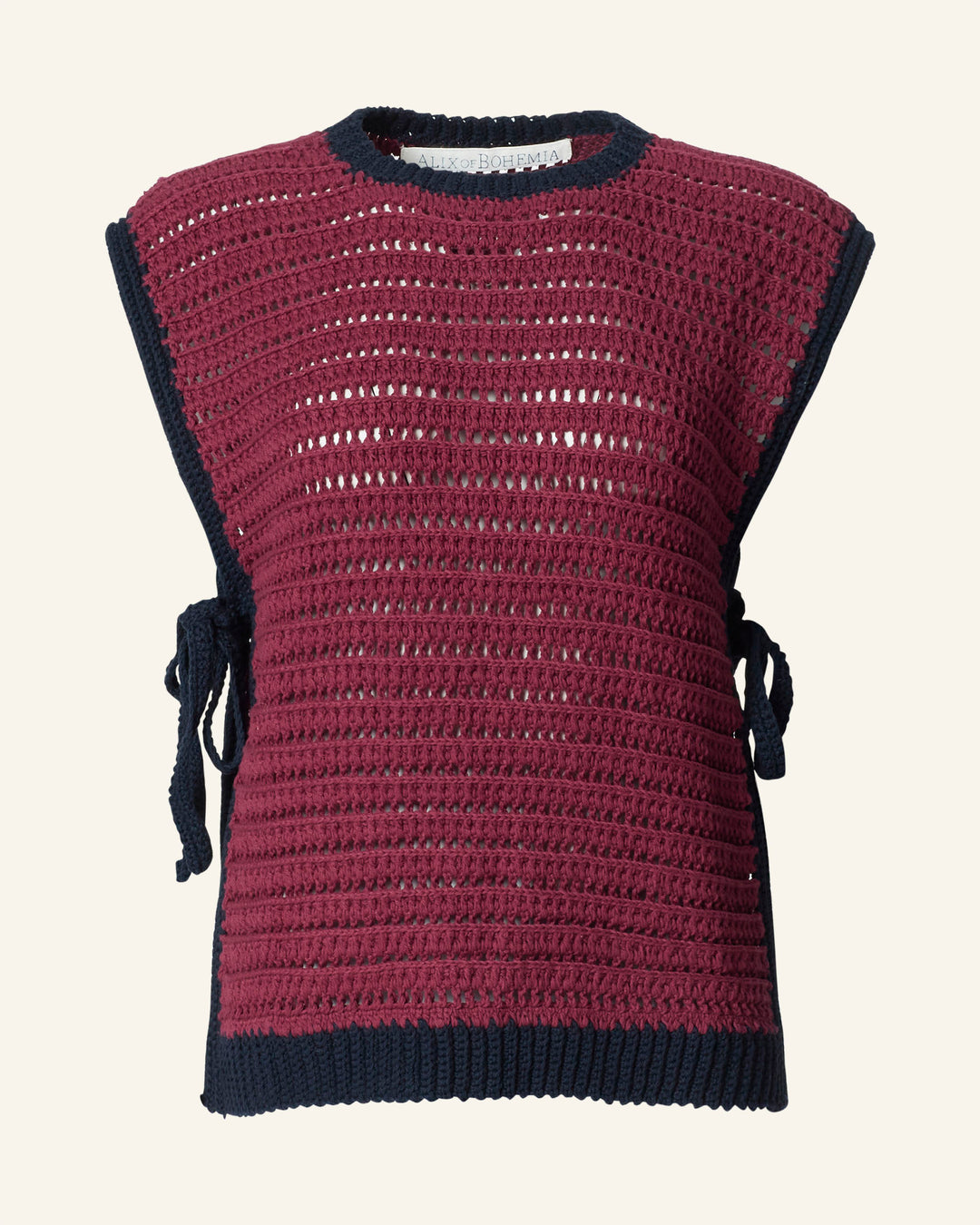 The Oona Mulberry Crochet Top is a hand-crocheted, sleeveless burgundy crop with navy trim, side ties, and an open knit design for a vintage-inspired look.