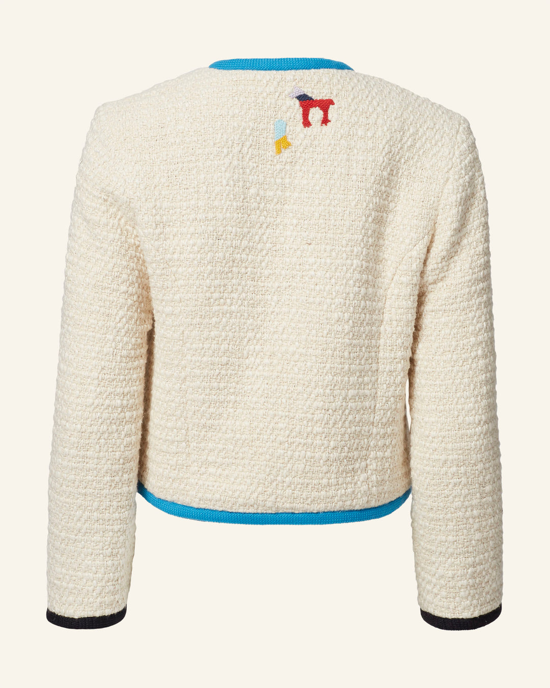 The Rowan Pearl Boucle Jacket is a cream-colored piece with long sleeves, adorned with small colorful embroidered motifs on the back. It features a cotton-silk lining and is finished with a blue trim along the neckline and hem.