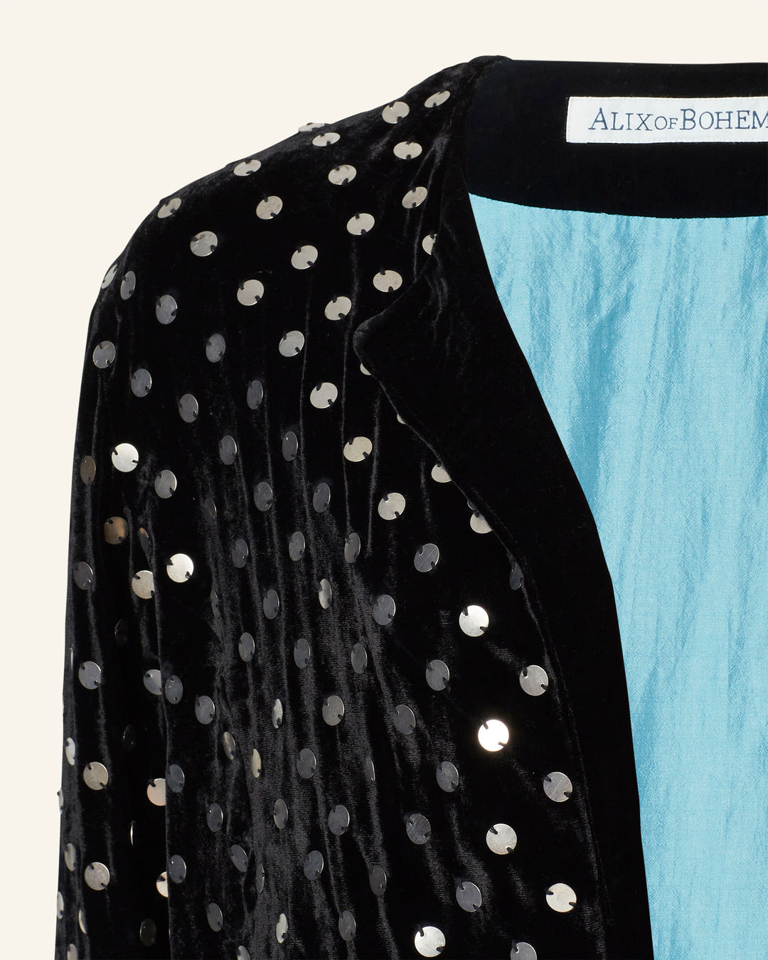 A close-up of the Rowan Stardust Velvet Jacket, featuring a hand-embellished design with sequin details and a blue lining.