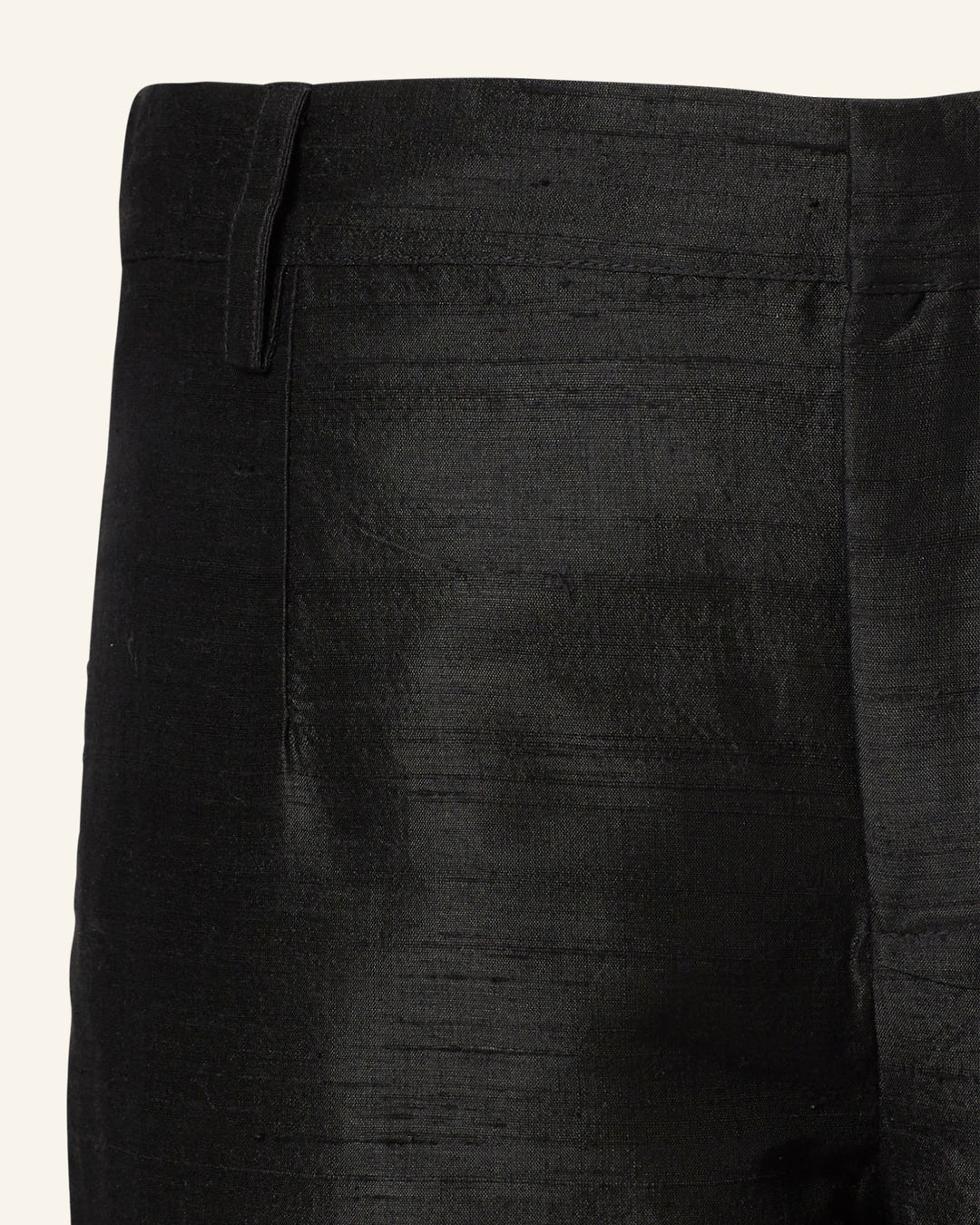 Close-up of Elinor Blackjack Silk Pant, black with a subtle sheen. It has a mid-rise waistband, straight-leg silhouette, and one left-side belt loop, perfectly complementing the Denali Blackjack Blazer.