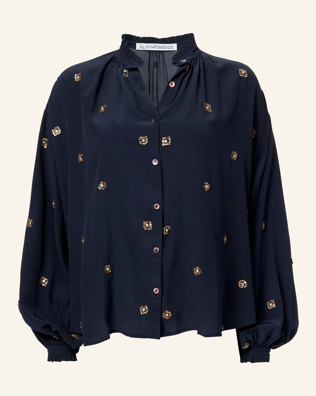 The Poet Casino Night Blouse is a vintage-inspired navy long-sleeve silk top, featuring a button-up front. Embellished with gold floral embroidery, it boasts a loose fit with gathered cuffs and a ruffled collar.