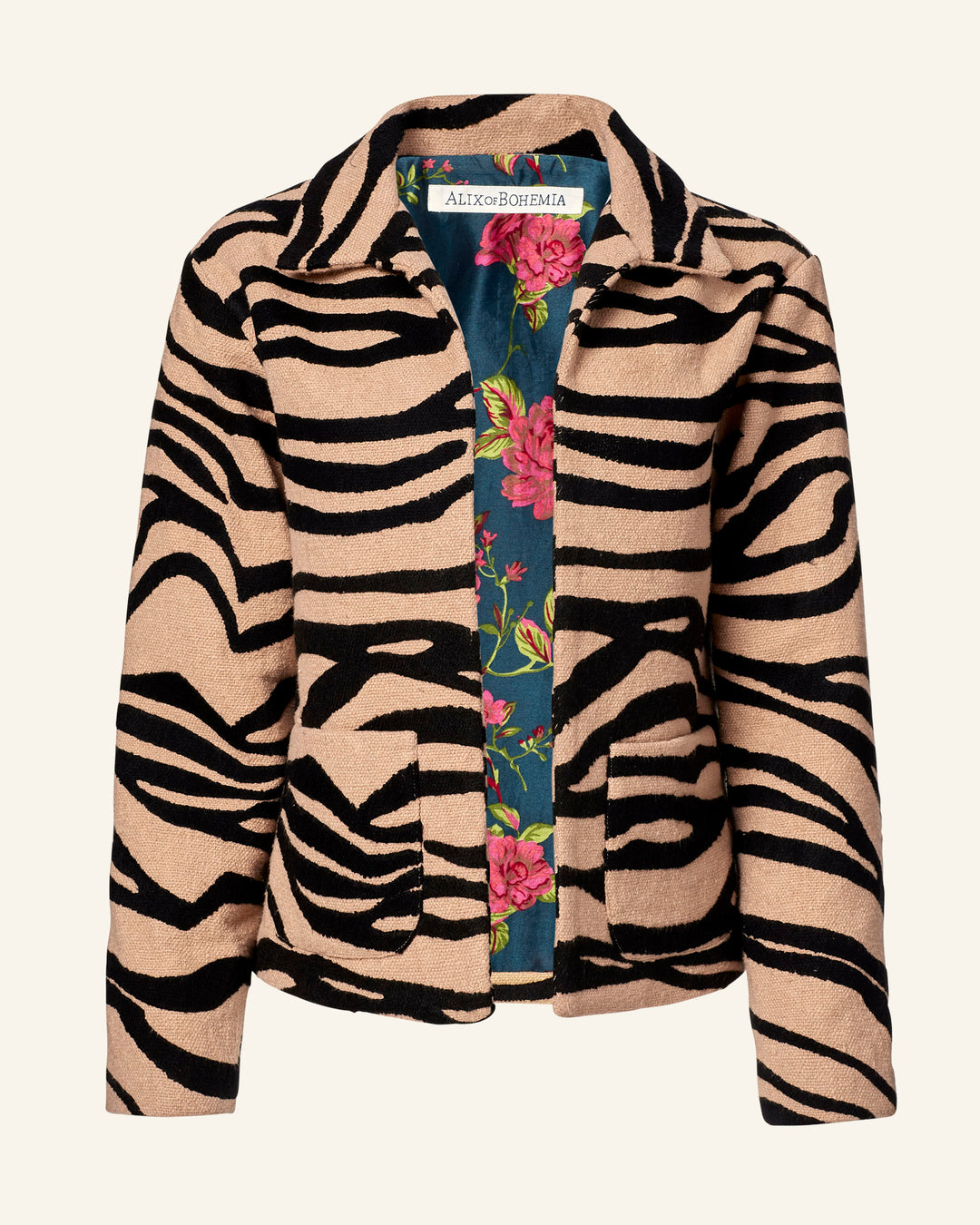 The Western Zebra Mirage Jacket features bold black and beige zebra stripes on a light background. Its Khadi cotton lining is adorned with vibrant red and pink flowers among green leaves. Inside, the label reads "AlexoBohemia.