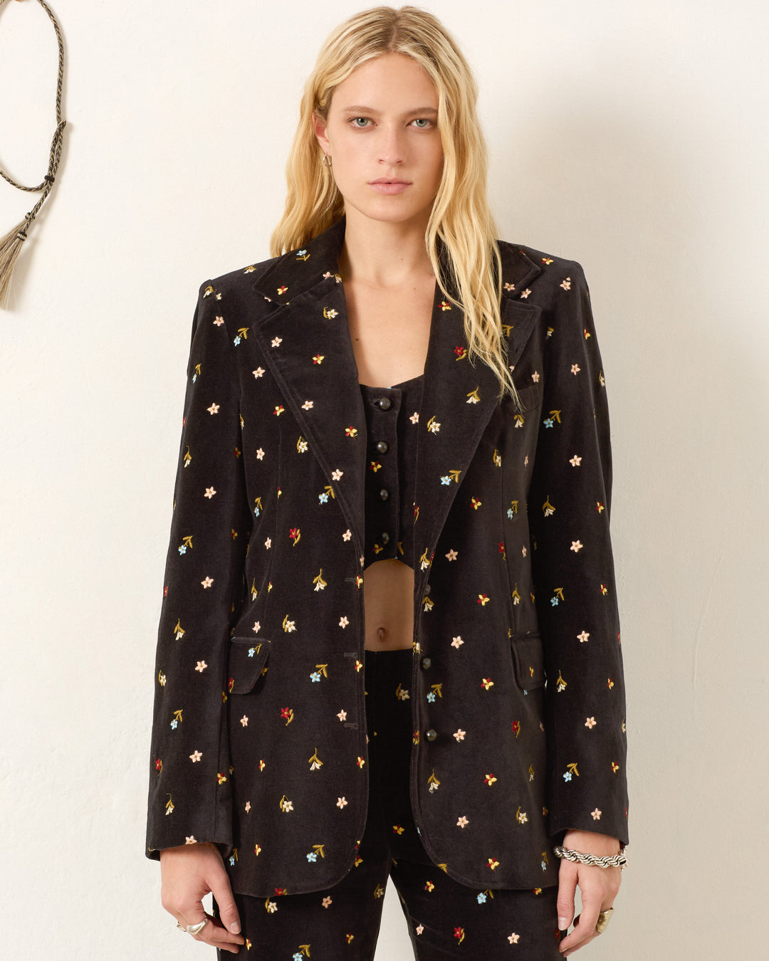 A woman in an Afternoon Onyx Bouquet Blazer with matching pants.