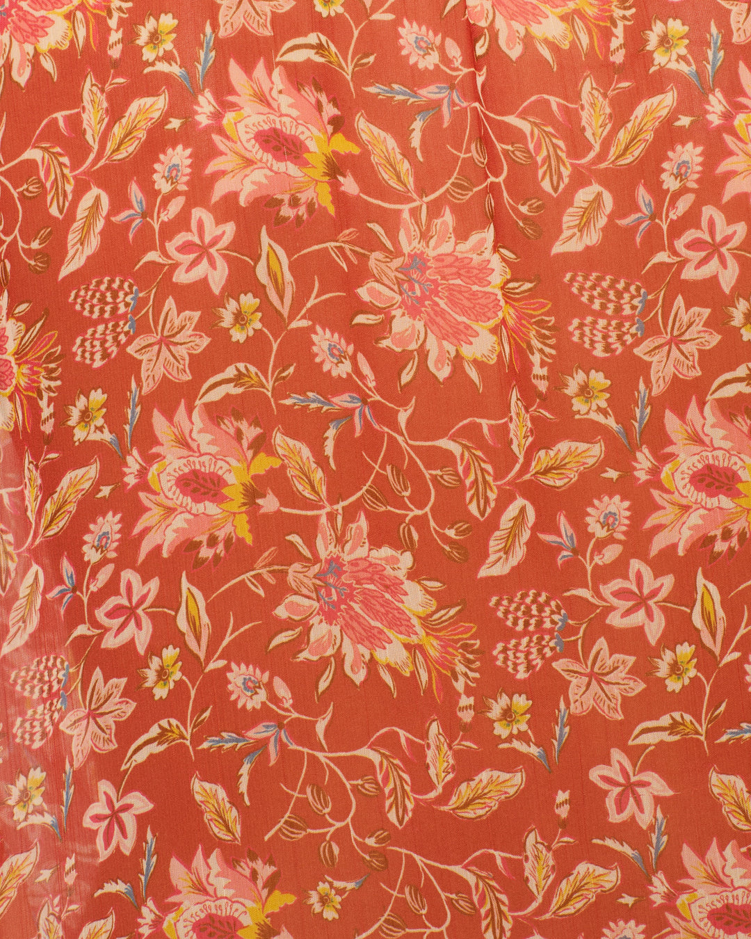 The Annabel Sunset Ember Shirt is crafted from red fabric with a floral pattern of pink, yellow, and white flowers and green leaves, ideal for creating puff shoulders or a delicate ruffled collar.