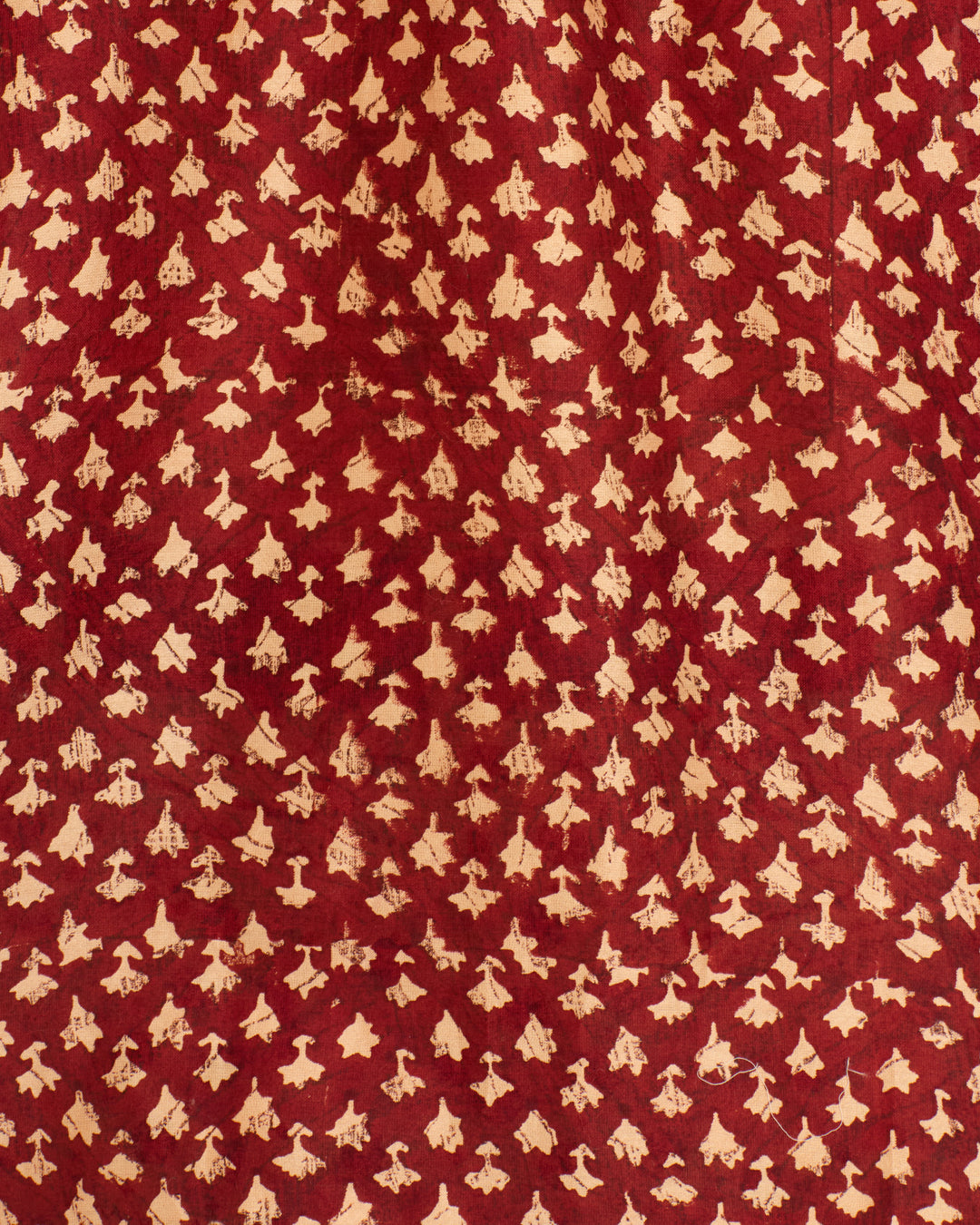 The Annabel Mahogany Bhutti Shirt features vintage-inspired red fabric with a repeating pattern of small, off-white abstract shapes—ideal for a hand-block printed cotton-silk blend shirt.