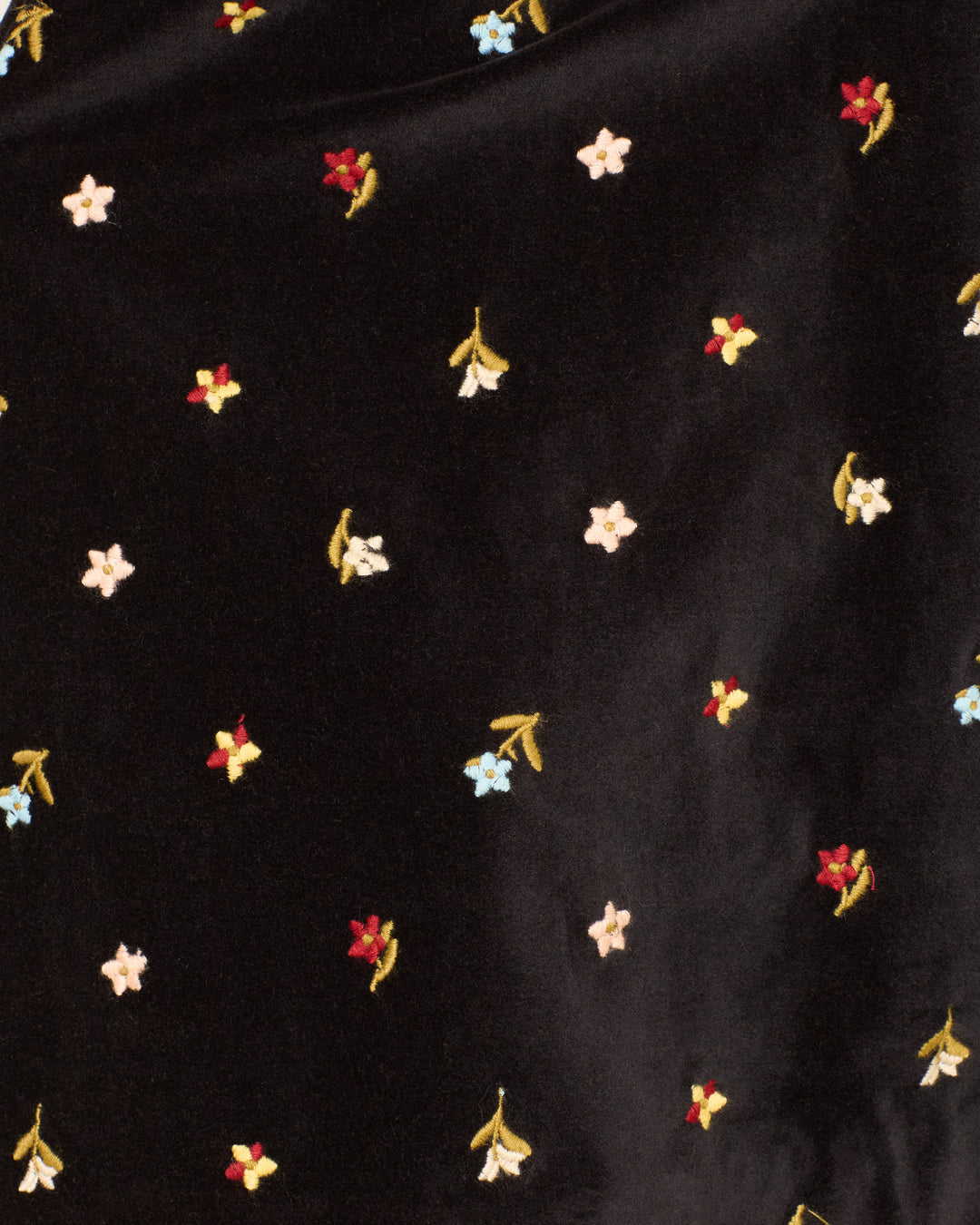 The Afternoon Onyx Bouquet Blazer features black cotton-velvet with delicate white, red, blue, and yellow floral embroidery, evenly spaced. Perfect for crafting a stylish blazer or matching pants for a chic look.