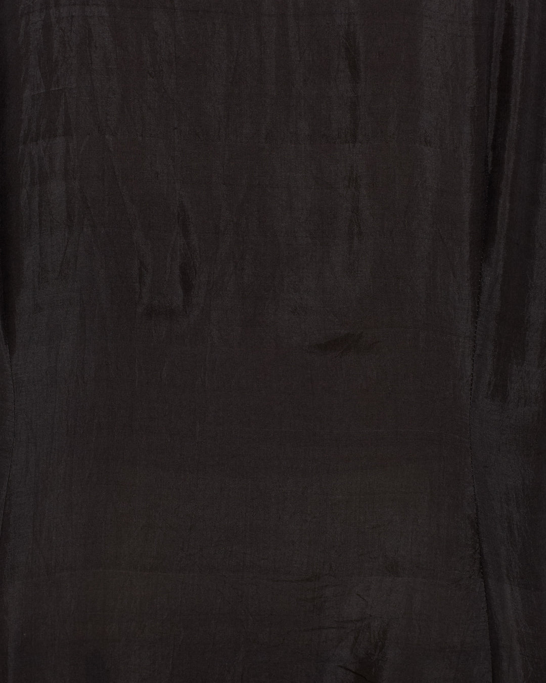 A close-up of the Dana Onyx Silk Shirt reveals its dark brown, slightly shiny silk fabric with subtle creases and texture, evoking a vintage-inspired style.