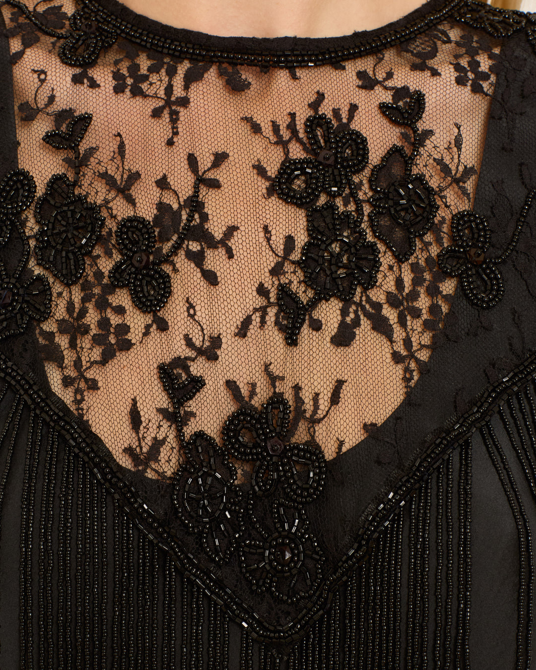 Close-up of the Flou Night Ride Lace Capelet, a vintage-inspired black dress with a lace capelet and hand-beaded floral embroidery on the neckline and upper chest.