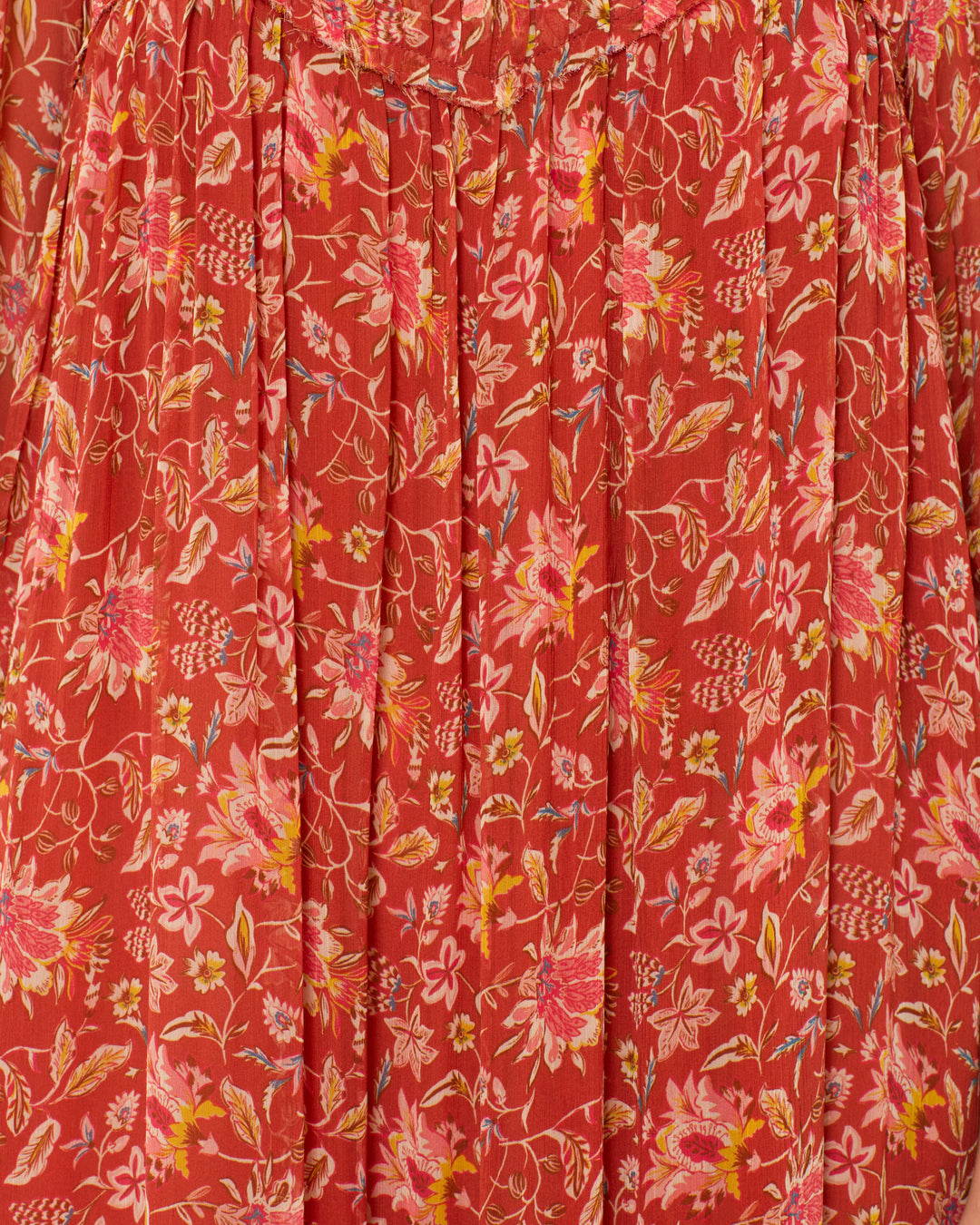 Close-up of red fabric with pink, yellow, and white florals and pleated details—perfect for the flowy Lilium Sunset Ember Dress.