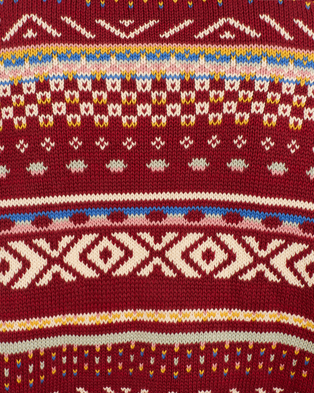 Close-up of the Liza Mesa Fair Isle Top, featuring vintage-inspired red knit fabric with white, yellow, blue, and brown geometric Fair Isle patterns.