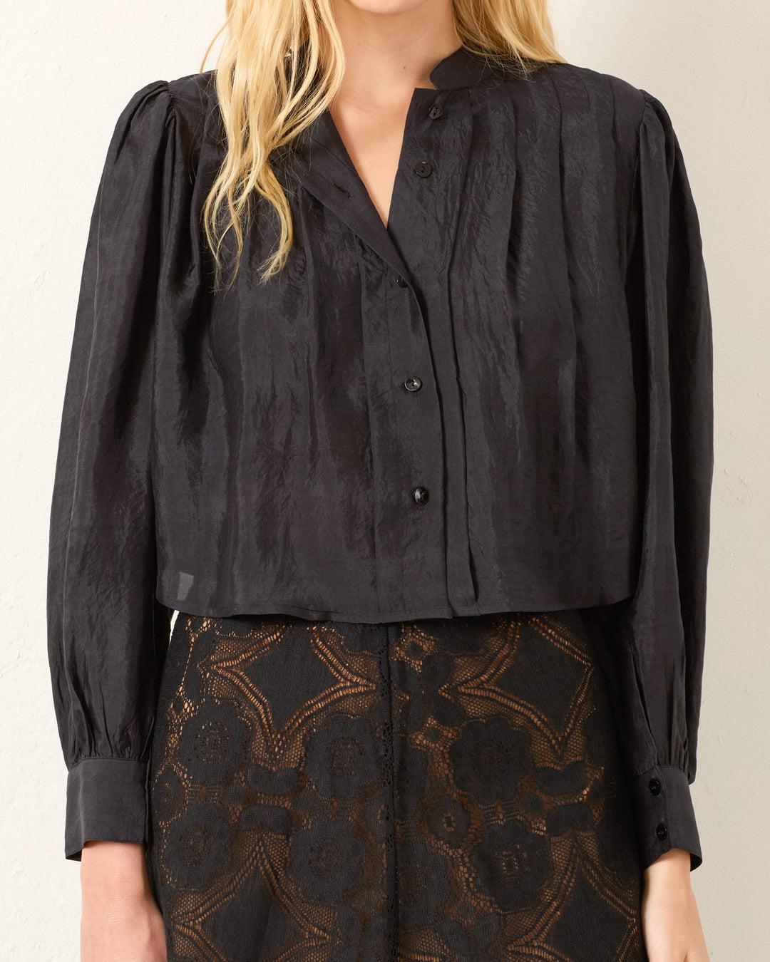 A woman wears the Ryle Onyx Silk Shirt, a black Victorian-style blouse with a subtle sheen, paired with a black lace skirt. Her face is not visible.