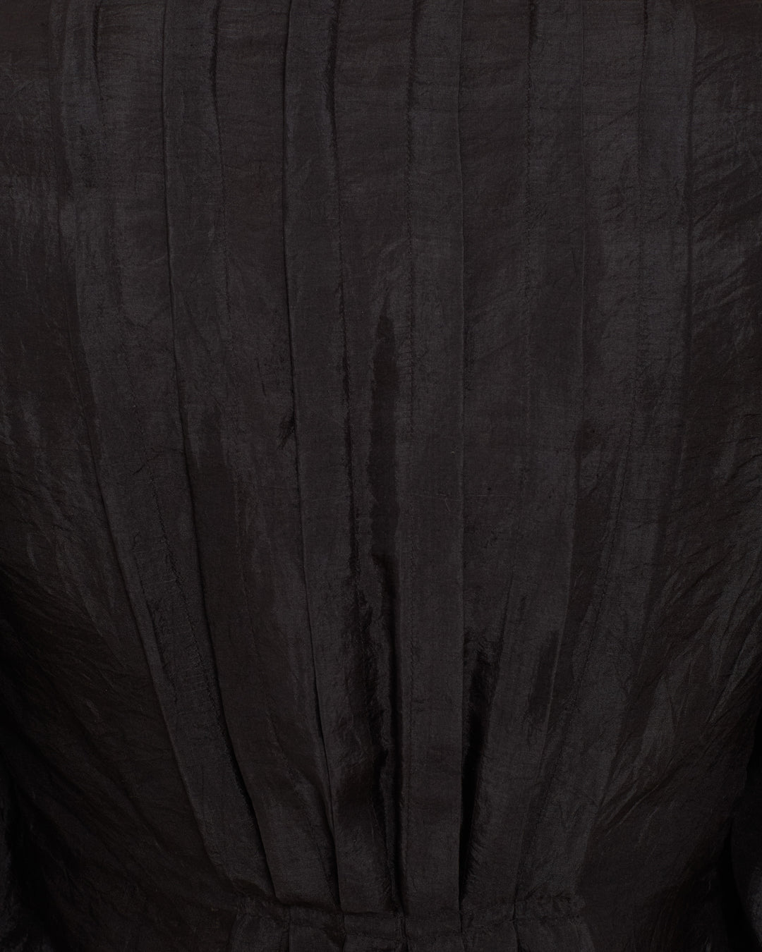 Close-up of the Ryle Onyx Silk Shirt, showcasing its dark, textured fabric and vertical pleats inspired by Victorian blouses.