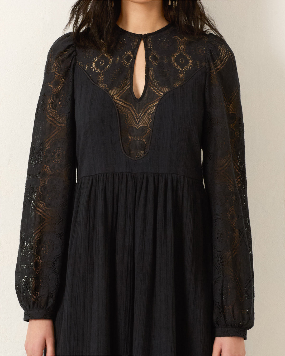 The Winifred Shadow Lace Dress features sheer floral lace long sleeves, lace detailing on the upper bodice, and a keyhole neckline—a stunning black maxi perfect for holiday parties.