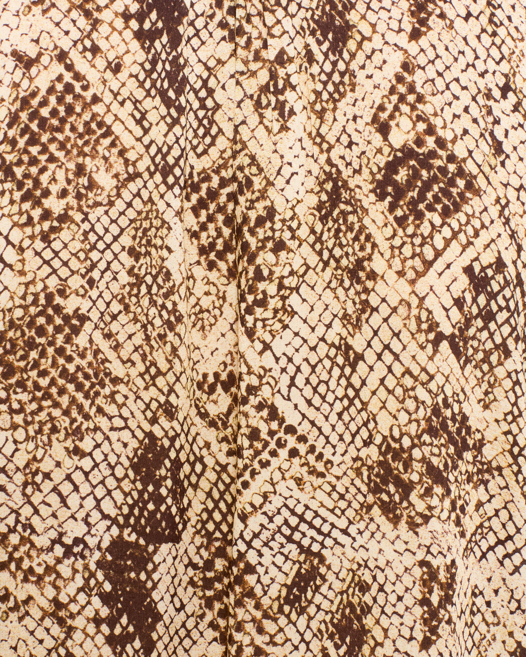 Close-up of the Annabel Lemon Snakeskin Shirt fabric in beige and brown, highlighting the detailed scales and irregular spots of its natural, abstract snakeskin print, with subtle views of a ruffled collar and gentle puff shoulders.