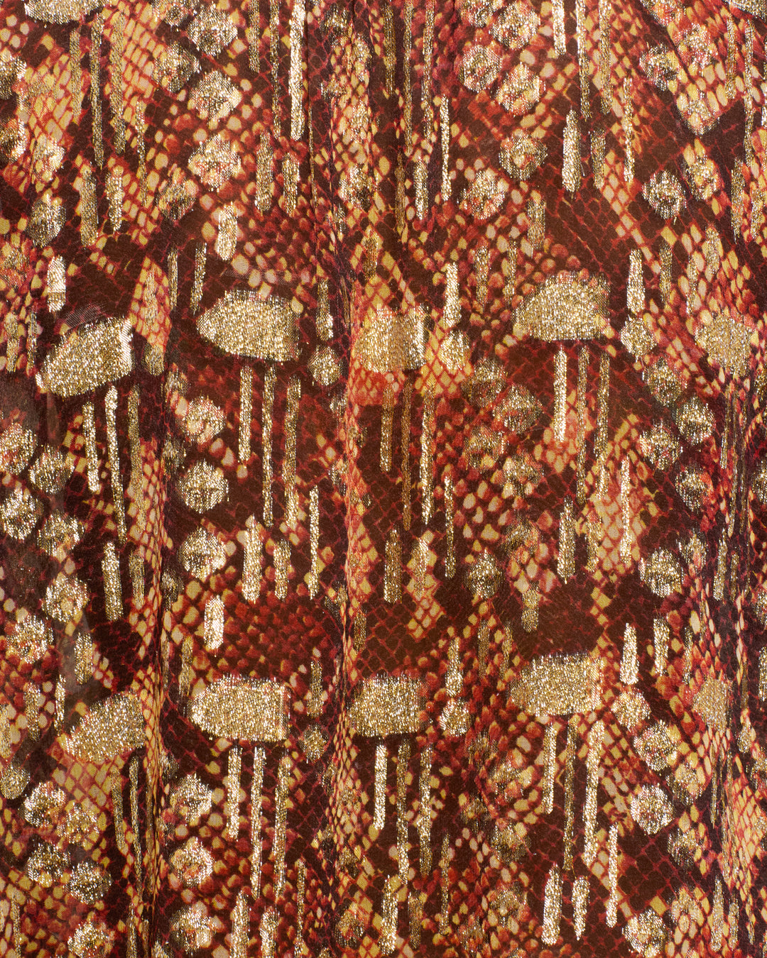 Close-up of the Annabel Topaz Snakeskin Shirt’s fabric, featuring a red, brown, and gold textured pattern with glittery accents resembling scales—perfect for a statement piece with puff shoulders or a ruffled collar.