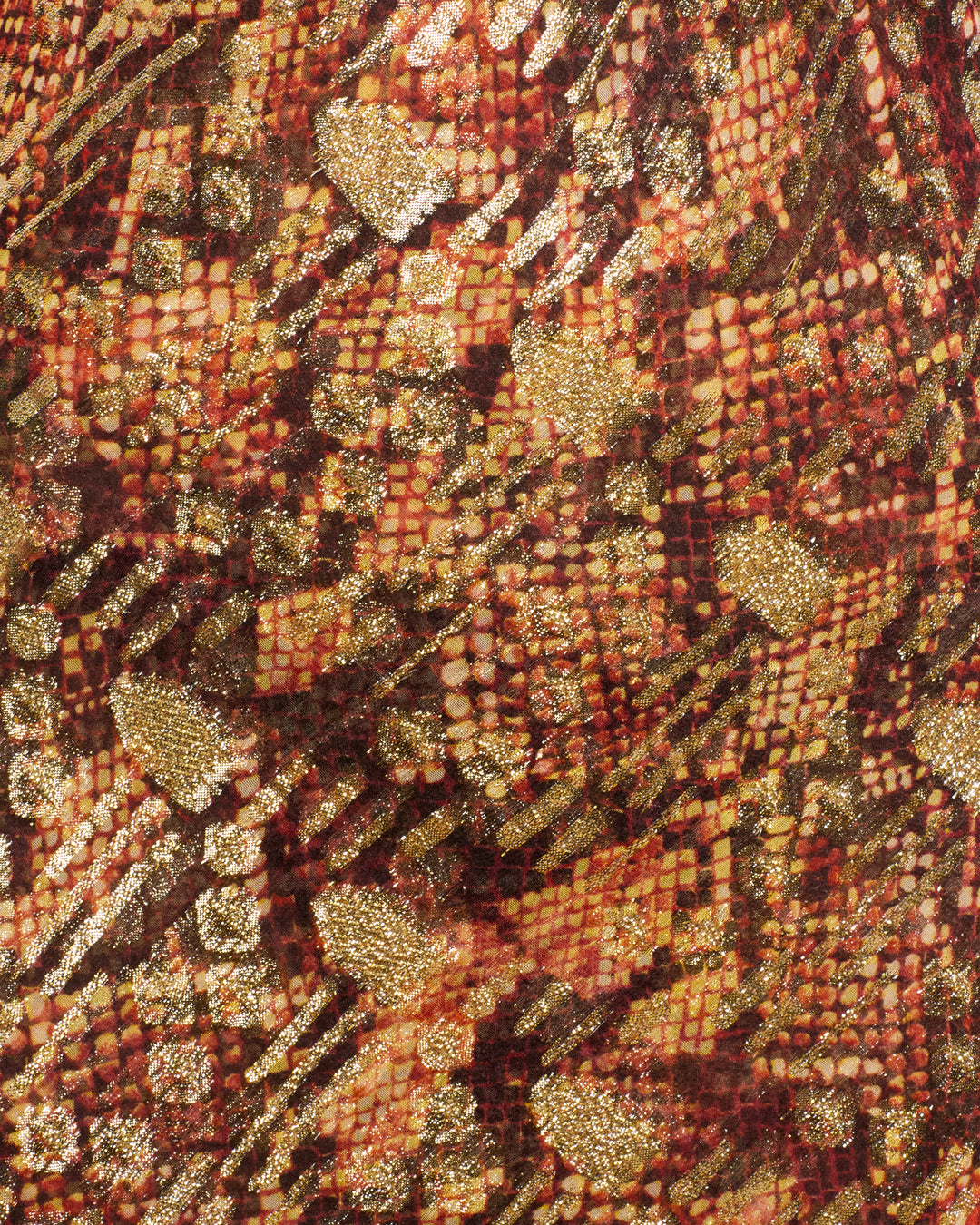Close-up of the Athens Topaz Snakeskin Dress, showcasing a red, black, and gold abstract snakeskin-inspired pattern with shiny, textured gold fil-coupé accents and geometric detailing.