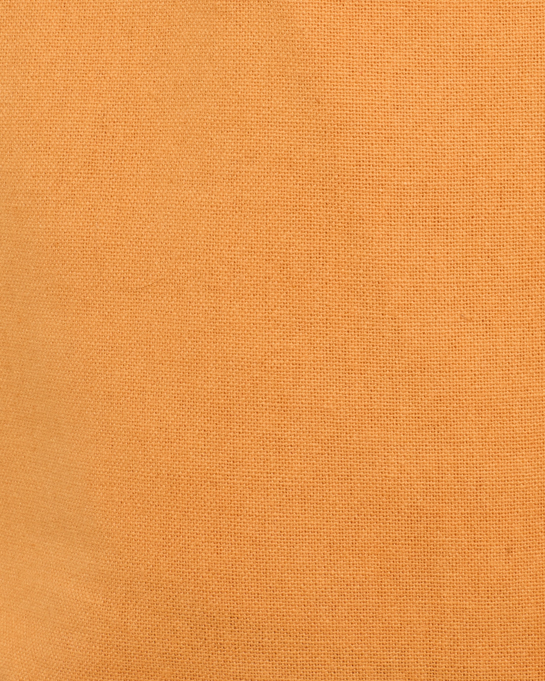 Close-up of the Bunny Sunset Fringe Pant’s textured orange fabric, showcasing a fine weave pattern reminiscent of classic Western-inspired jean-cut pant styles.