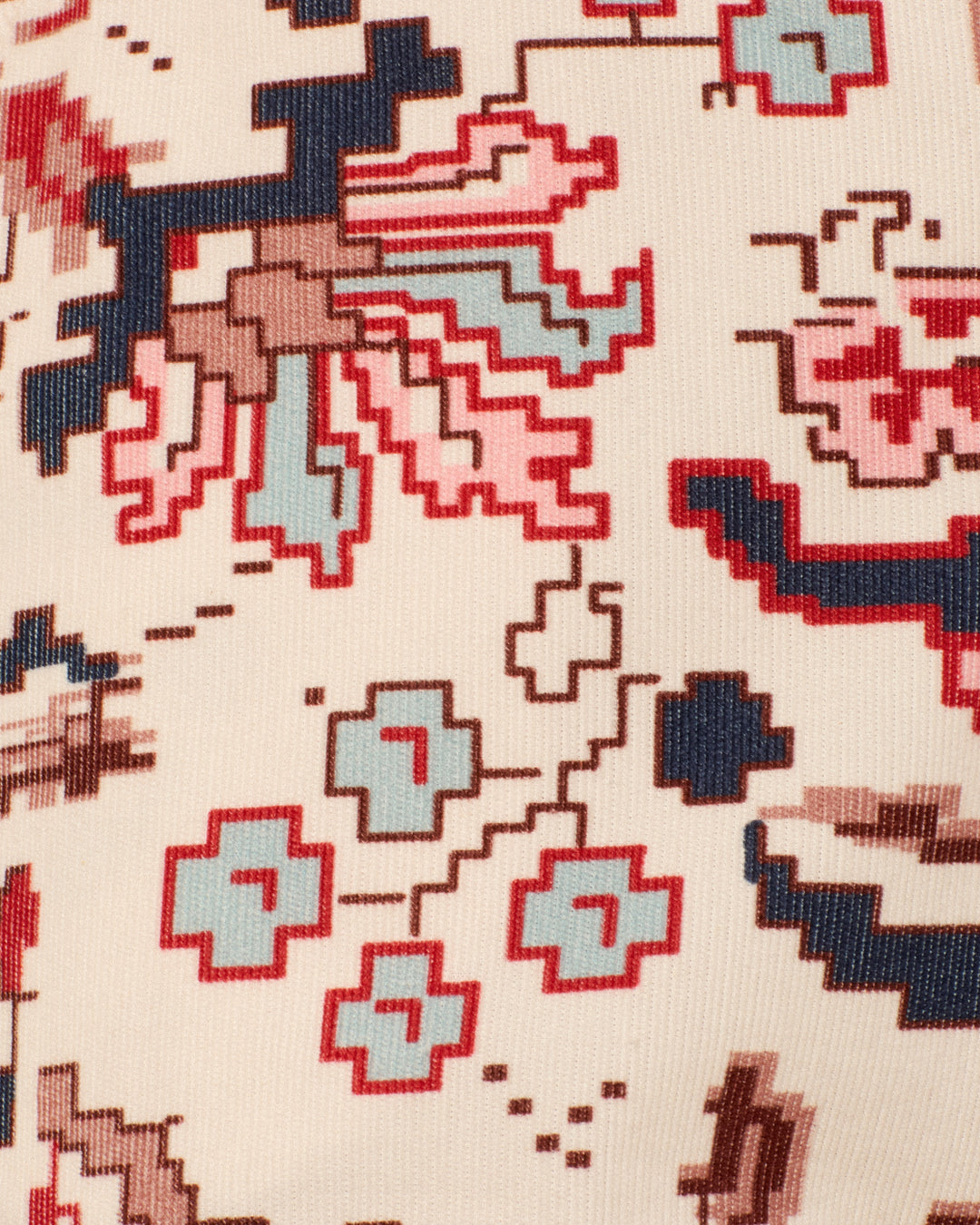 Close-up of the Charlie Horizon Kilim Pant’s fabric, featuring a kilim-inspired, pixelated floral pattern in red, blue, brown, and black on a beige background.