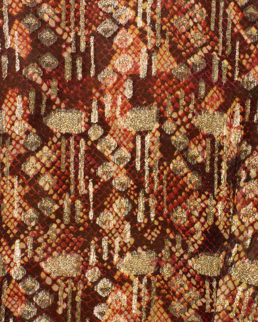 The Dana Topaz Snakeskin Shirt features striking red and gold geometric diamond patterns and vertical gold lines, blending glittery and matte textures for a lavish fil-coupé effect. Reminiscent of vintage ’70s styles, this shirt reimagines the iconic dagger collar in luxe, modern materials.