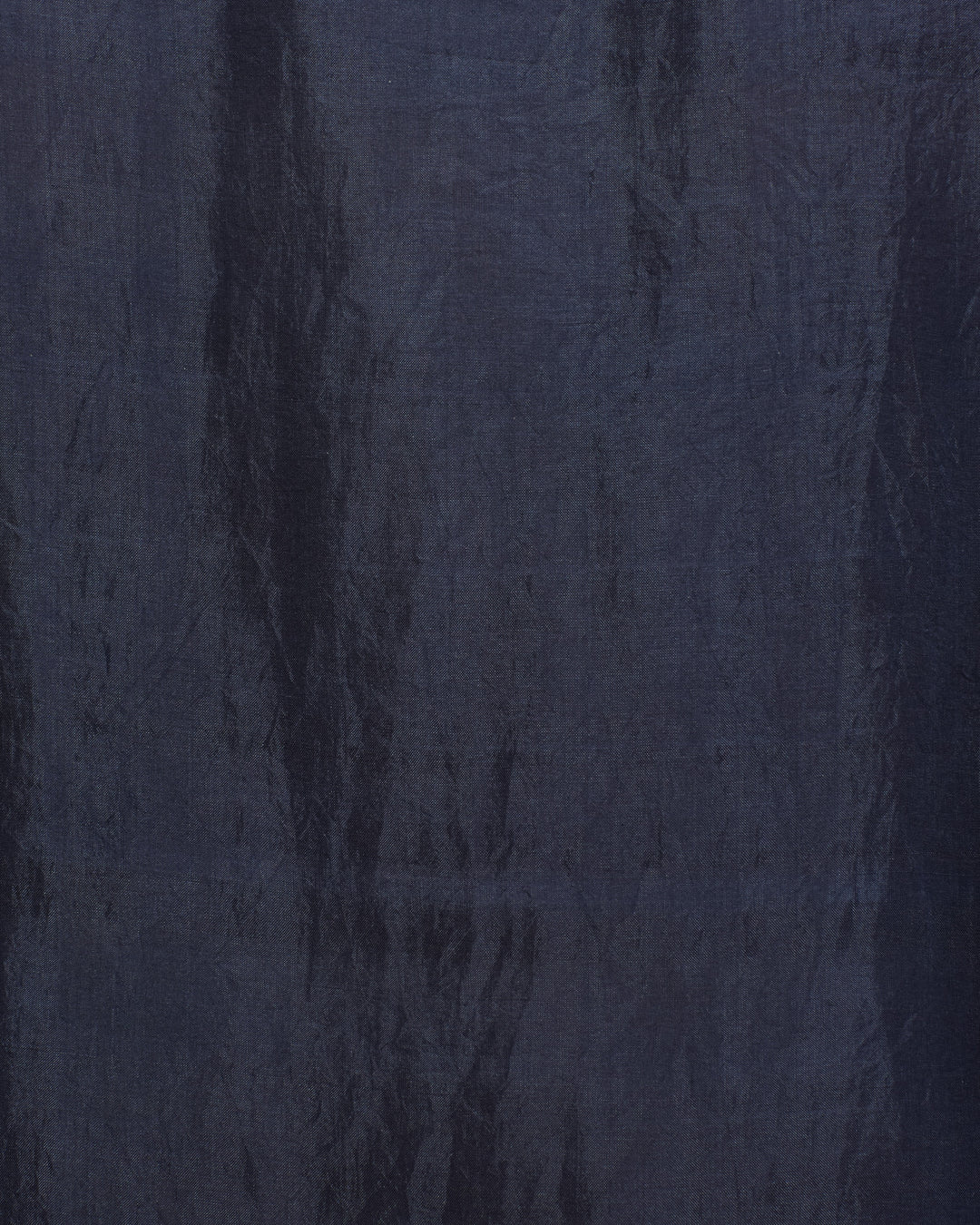 Deep indigo blue silk shirt featuring a textured finish with subtle vertical creases and varied shading throughout the surface, reminiscent of an artisan-crafted or vintage-inspired garment; the Dana Indigo Night Silk Shirt.