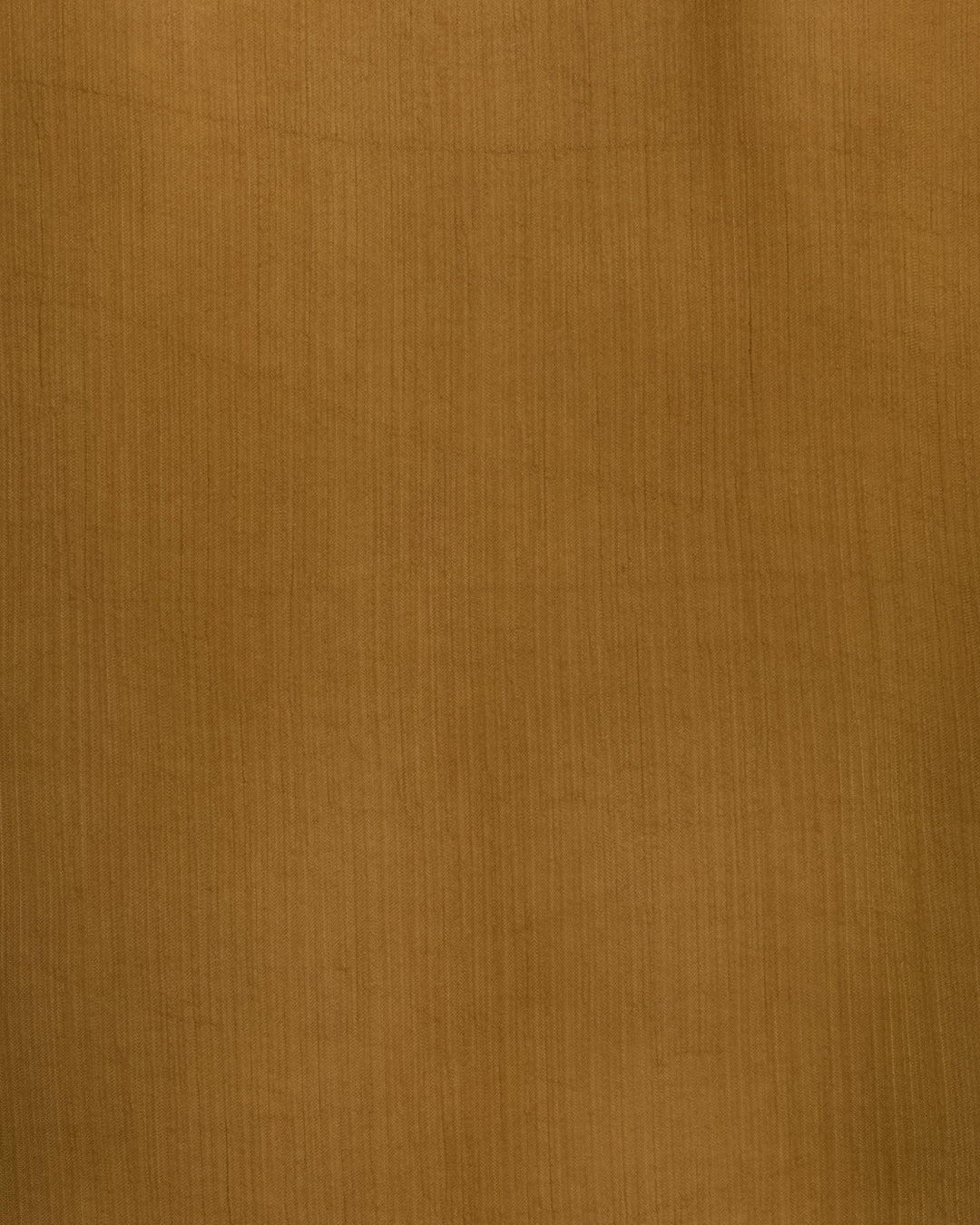 Close-up of a brown textured surface with subtle vertical lines and shading variations, evoking the delicate elegance of the Dana Olive Chiffon Shirt.