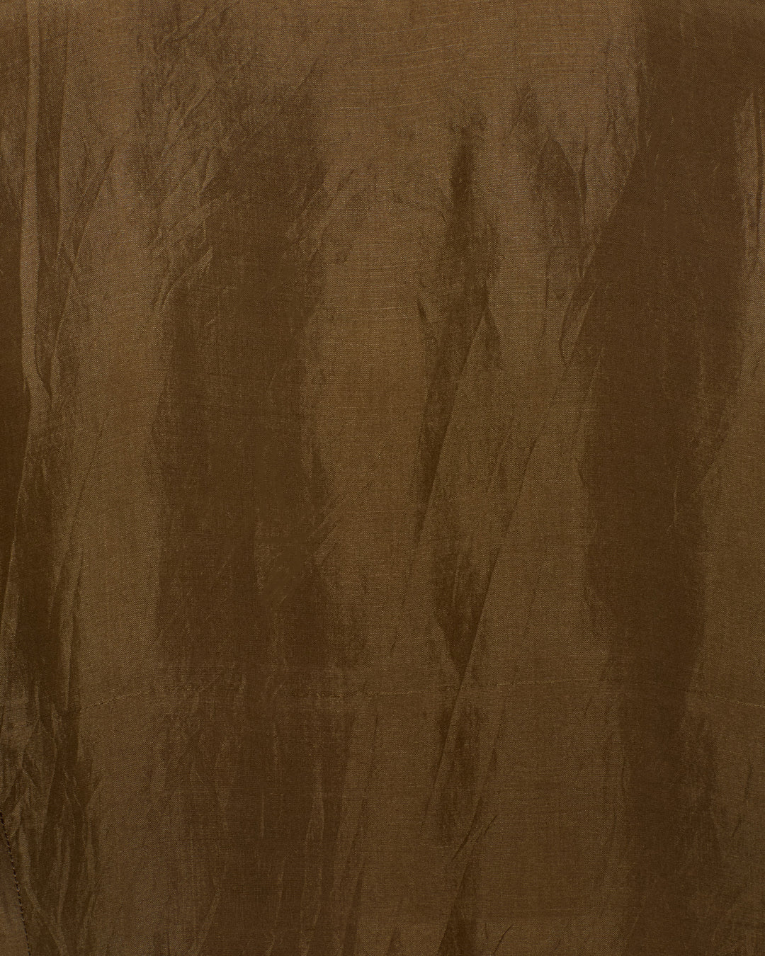 The Dana Olive Branch Silk Shirt features brown fabric with a slightly wrinkled texture and subtle vertical and diagonal lines across the surface, evoking a vintage-inspired look.