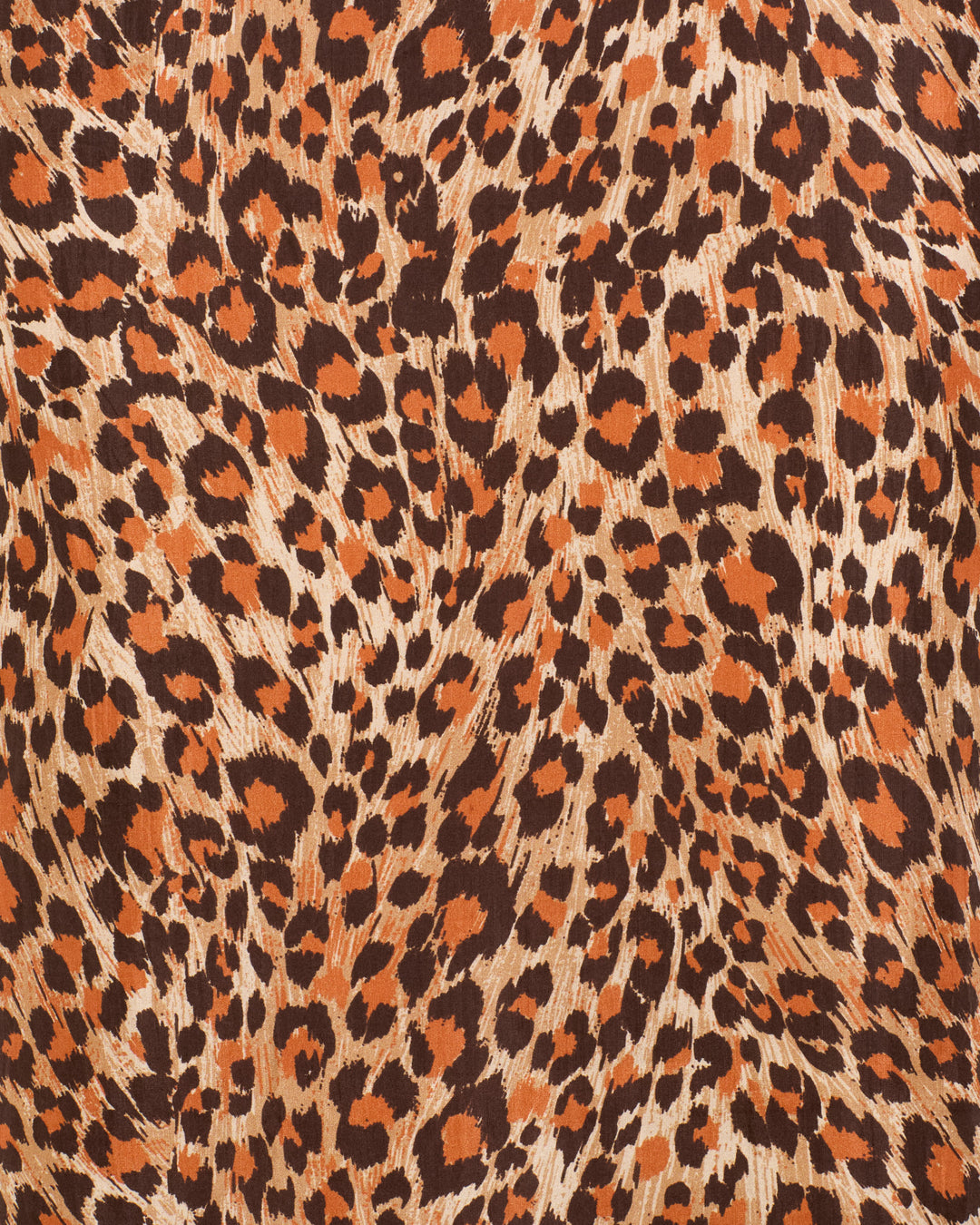 Close-up view of the Daph Leopard Trek Silk Dress, highlighting its hand-loomed silk fabric with a striking leopard print pattern of black and orange spots on a tan background.