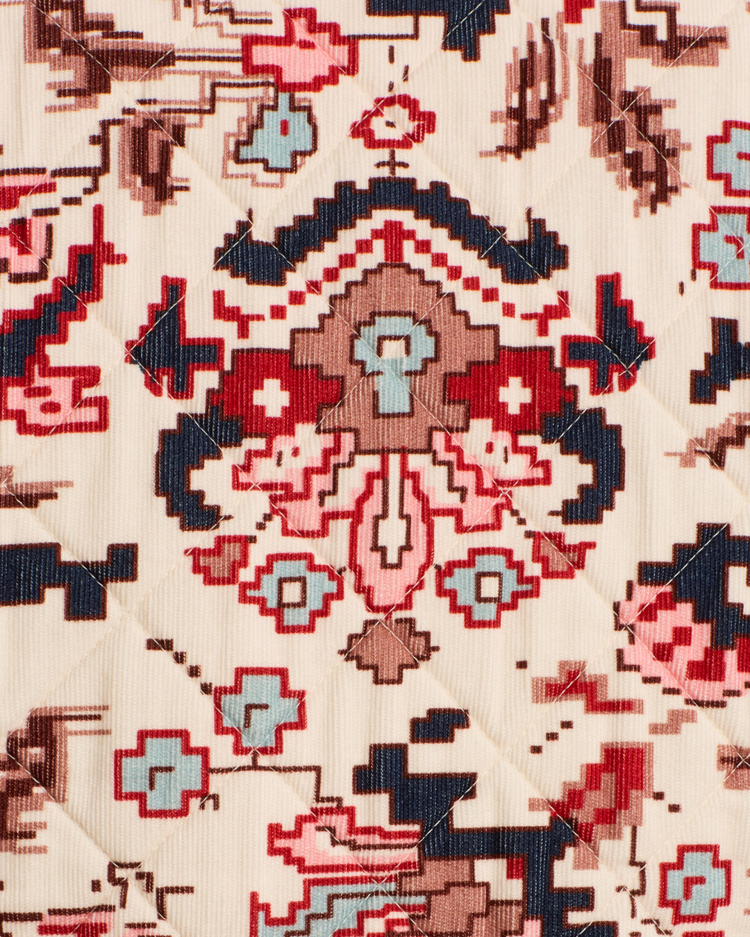 Close-up of quilted fabric from the Dorian Horizon Kilim Jacket, featuring a geometric and abstract pattern in red, blue, brown, and beige tones with a collarless design and cropped silhouette.